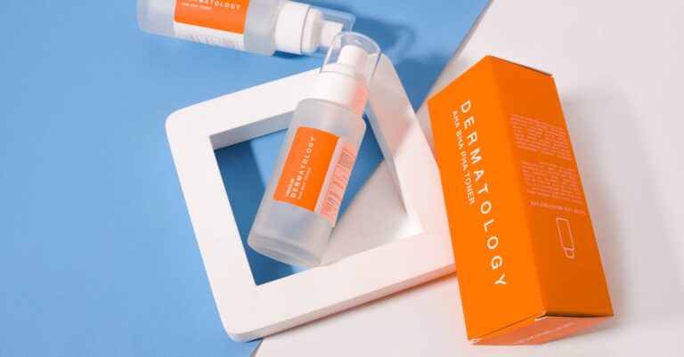 Stylish presentation of dermatology skincare products with orange packaging on a geometric background.