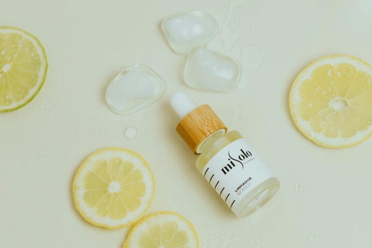Close-up shot of a cosmetic dropper bottle with lemon slices and ice.