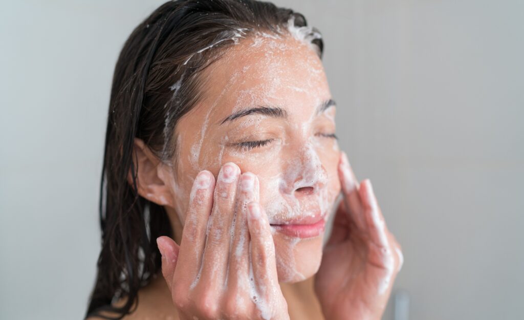 A girl washing her face with a facial cleanser.