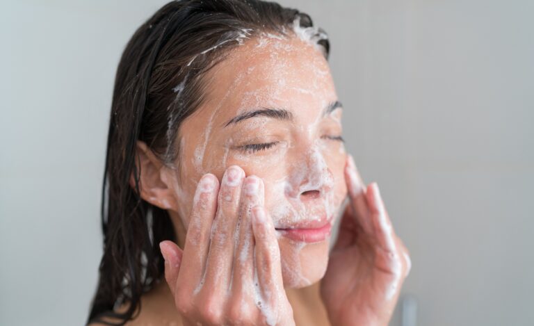 A girl washing her face with a facial cleanser.